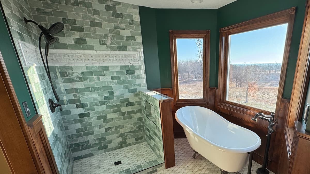 Bathroom with stained wood wainscoting and window casings around a clawfoot tub