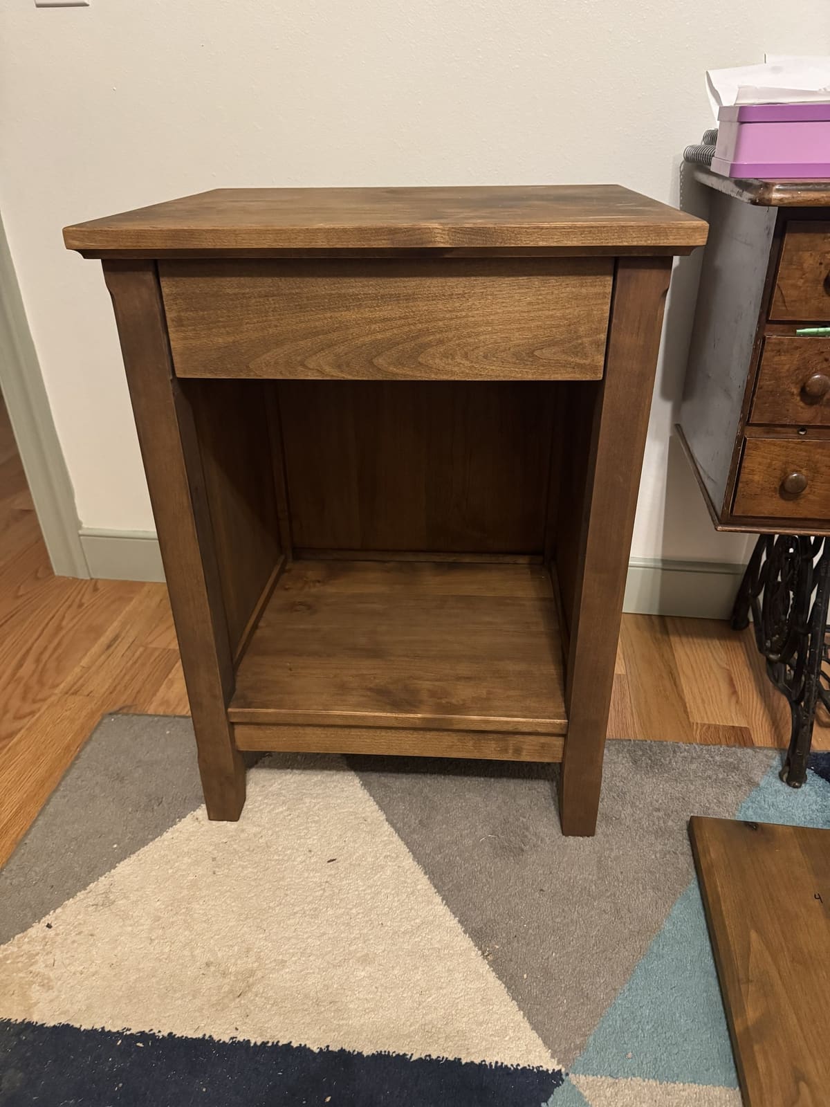 Nightstand as built, in a medium brown stain with one drawer and an open lower shelf